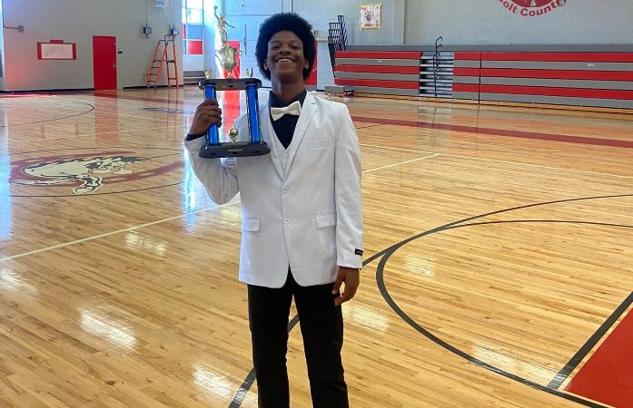 Antone Harris holding the Basketball Championship Trophy